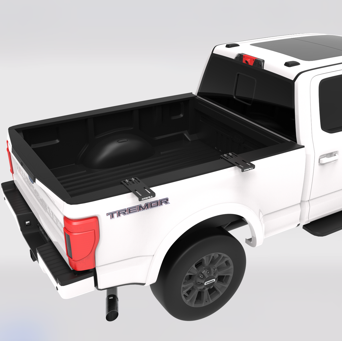 A white pickup truck shown from the rear three-quarter angle, featuring a black bed liner installed in the truck bed. The truck is set against a clean, light gray studio background. STAPLL side mount bike rack.